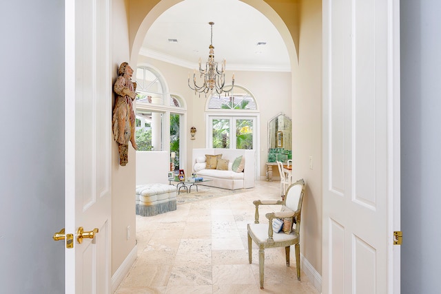 living area featuring crown molding and a chandelier