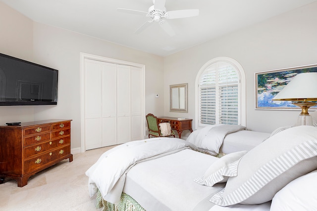 bedroom with ceiling fan, a closet, and light colored carpet