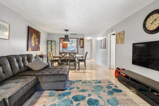 living room with a textured ceiling and light tile patterned flooring