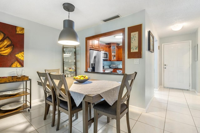 tiled dining area with a textured ceiling