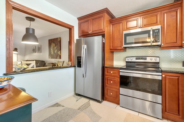 kitchen with appliances with stainless steel finishes, tasteful backsplash, decorative light fixtures, and dark stone counters