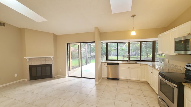 kitchen with white cabinetry, sink, hanging light fixtures, light stone counters, and appliances with stainless steel finishes