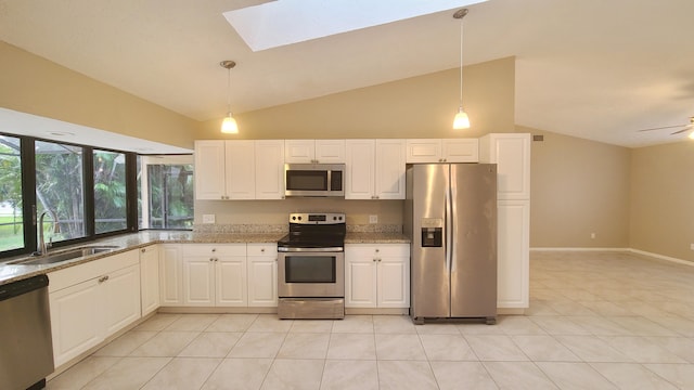 kitchen featuring pendant lighting, lofted ceiling with skylight, sink, and appliances with stainless steel finishes