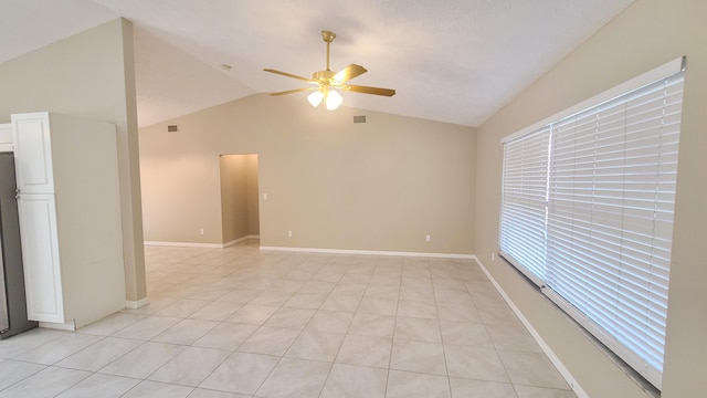 unfurnished room with ceiling fan, lofted ceiling, and light tile patterned flooring