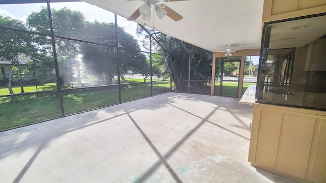 unfurnished sunroom featuring ceiling fan and sink