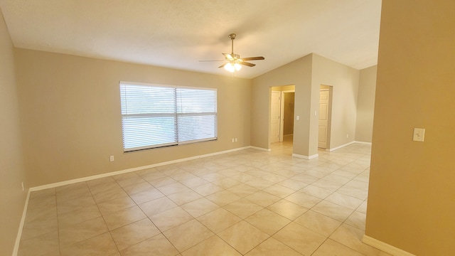 tiled spare room featuring vaulted ceiling and ceiling fan