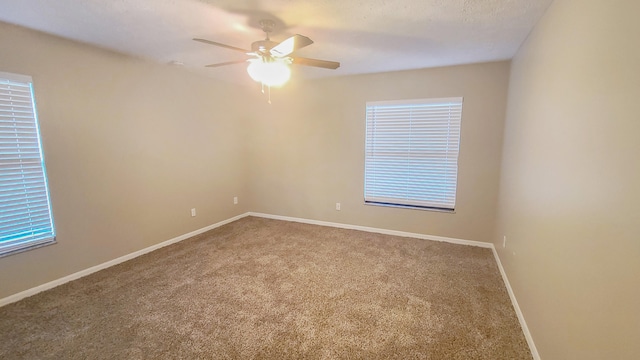 carpeted spare room with ceiling fan