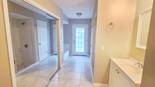 bathroom with tile patterned flooring, vanity, a textured ceiling, and plus walk in shower