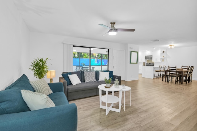 living room with ceiling fan and light wood-type flooring