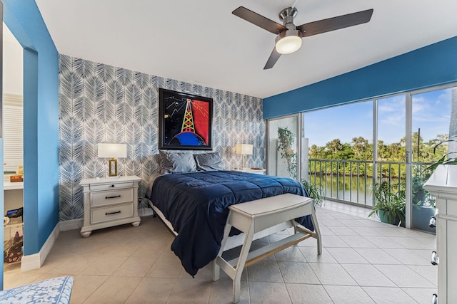 bedroom with access to exterior, ceiling fan, a water view, and light tile patterned floors