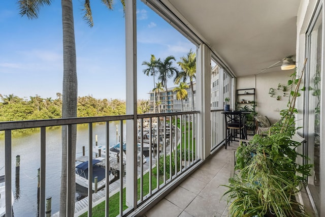 balcony featuring a water view and ceiling fan