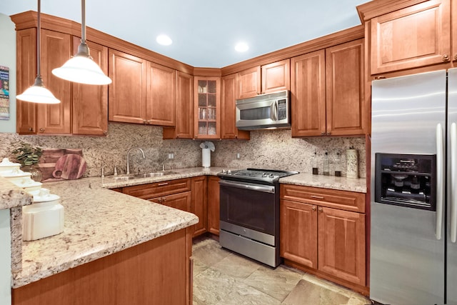 kitchen with sink, tasteful backsplash, decorative light fixtures, light stone counters, and stainless steel appliances