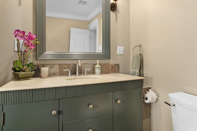 bathroom featuring vanity, toilet, and crown molding