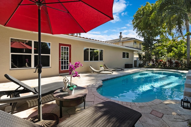 view of pool featuring cooling unit and a patio area