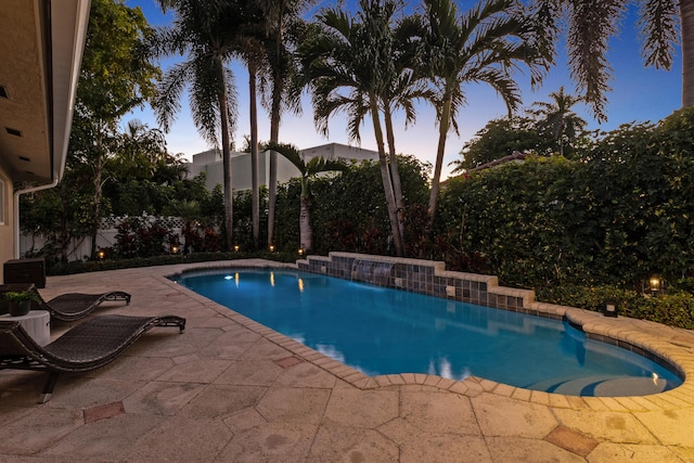 pool at dusk featuring a patio