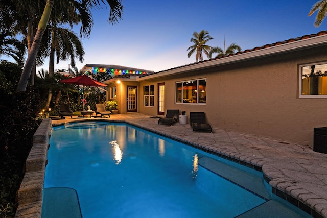 pool at dusk with a patio