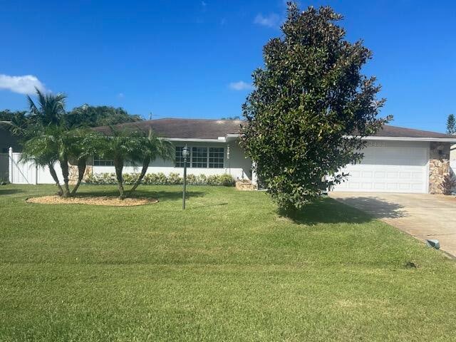 single story home with a garage and a front lawn