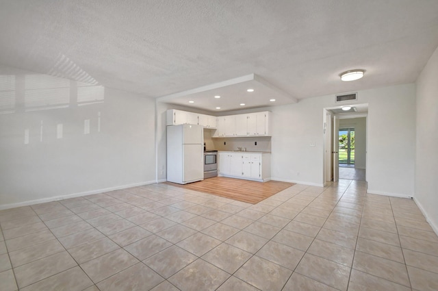 unfurnished living room with light tile patterned floors and a textured ceiling