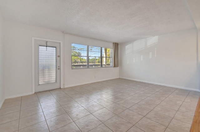 empty room featuring light tile patterned floors and a textured ceiling