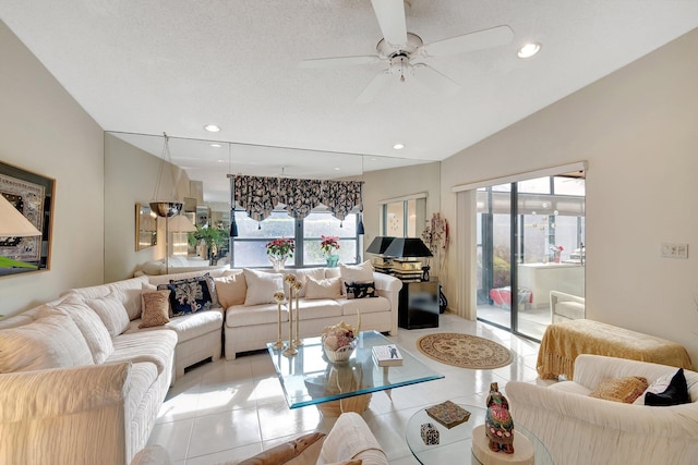 tiled living room with ceiling fan, a textured ceiling, and vaulted ceiling