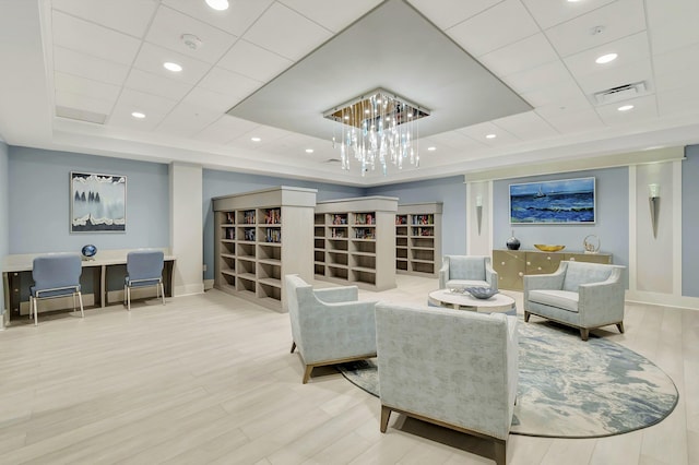 interior space featuring hardwood / wood-style flooring, a paneled ceiling, and a tray ceiling