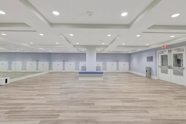 exercise room featuring coffered ceiling, light hardwood / wood-style flooring, and french doors