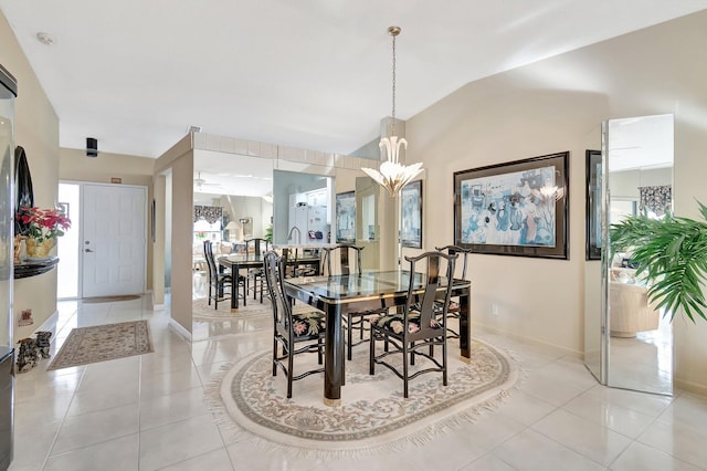 dining space featuring light tile patterned floors, lofted ceiling, and a notable chandelier