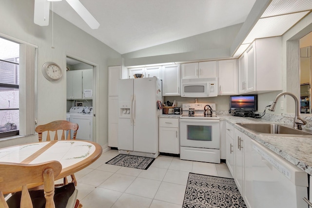 kitchen with white appliances, vaulted ceiling, sink, light tile patterned floors, and white cabinets