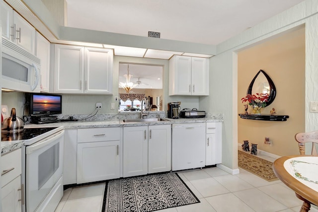 kitchen featuring white cabinetry, sink, light stone countertops, white appliances, and light tile patterned flooring