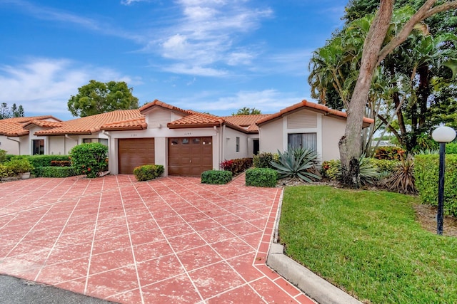 mediterranean / spanish home with a front yard and a garage