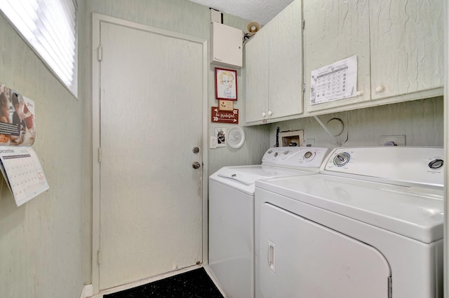 washroom with washer and dryer and cabinets