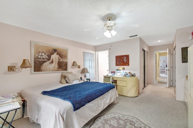 bedroom featuring ceiling fan, light colored carpet, a textured ceiling, and a closet