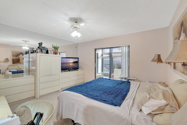 bedroom with a textured ceiling, light colored carpet, and ceiling fan