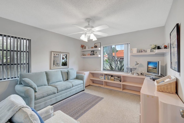 living room featuring ceiling fan, a textured ceiling, and light carpet