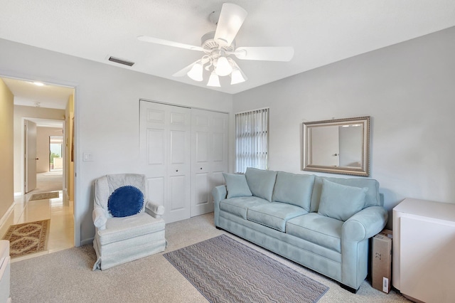 living room with ceiling fan and light colored carpet