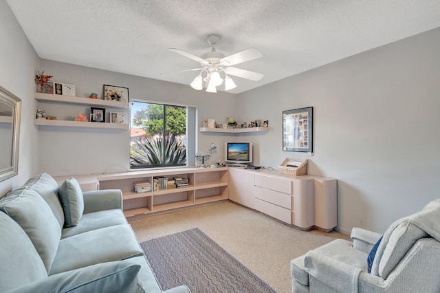 living room with ceiling fan, light colored carpet, and a textured ceiling