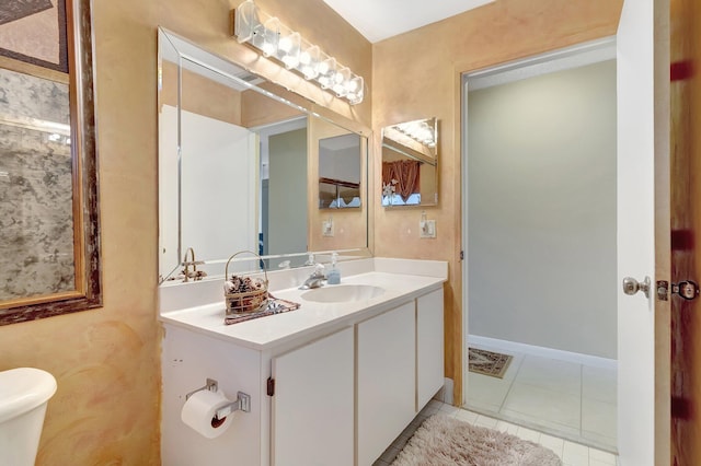 bathroom featuring tile patterned flooring, vanity, and toilet