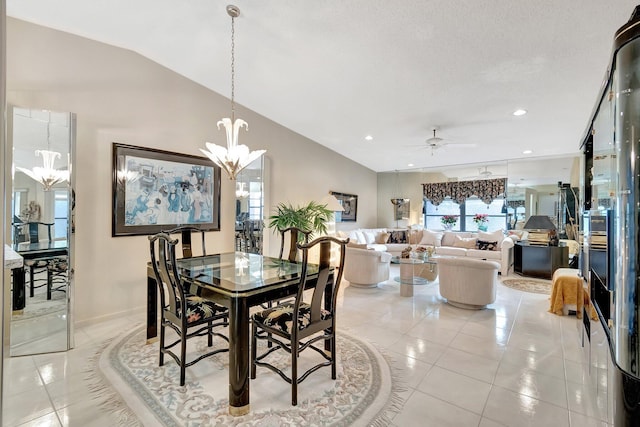 dining room with ceiling fan with notable chandelier, light tile patterned flooring, and vaulted ceiling