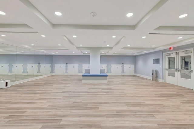 workout area with coffered ceiling, light hardwood / wood-style floors, and french doors