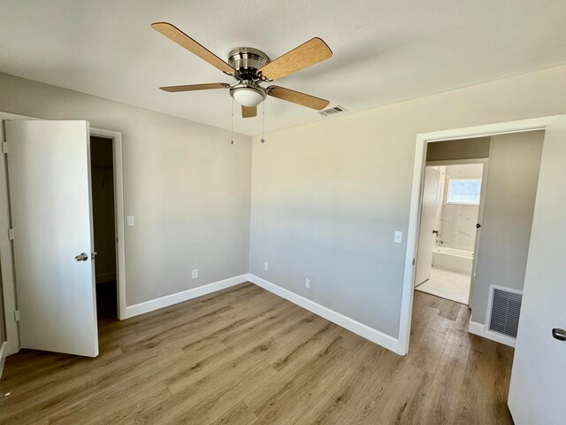 unfurnished bedroom with ceiling fan and light wood-type flooring