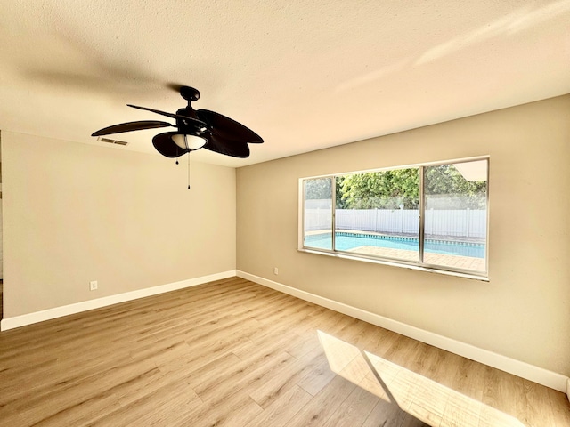 spare room featuring a textured ceiling, light hardwood / wood-style flooring, and ceiling fan