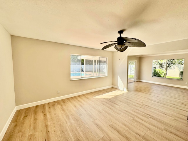 empty room with ceiling fan, light hardwood / wood-style floors, and a textured ceiling