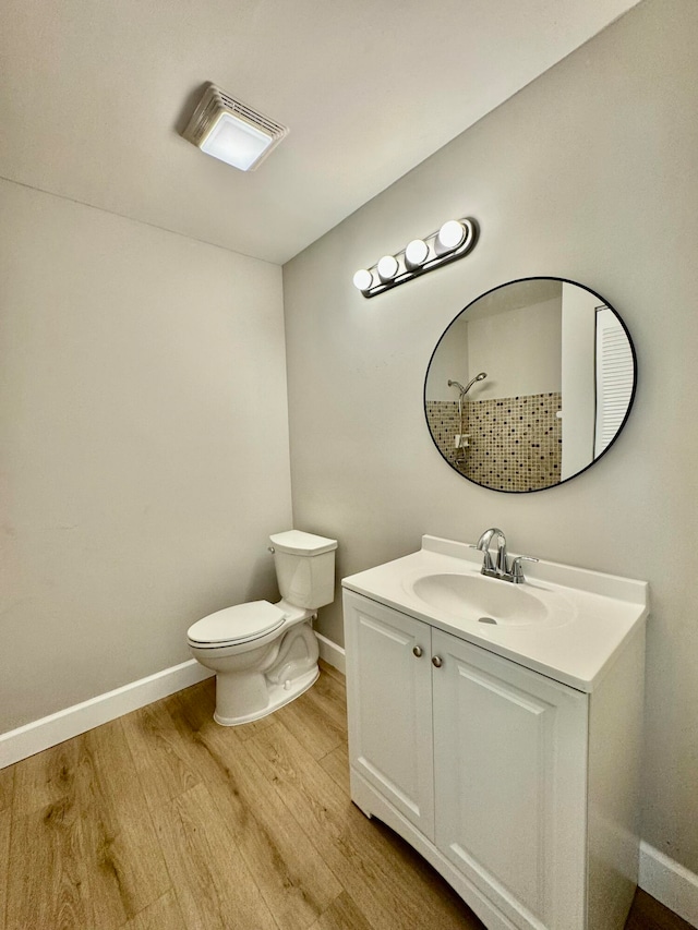 bathroom with hardwood / wood-style floors, vanity, and toilet