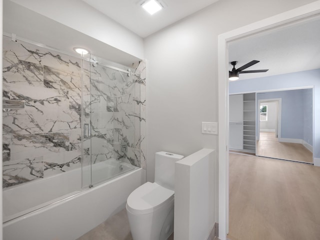 bathroom featuring wood-type flooring, toilet, ceiling fan, and bath / shower combo with glass door