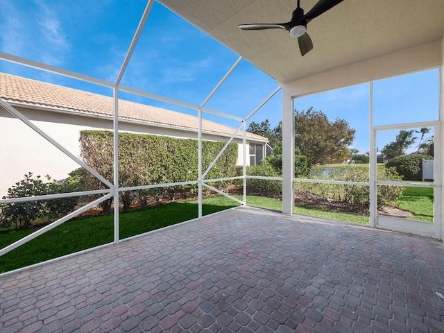 unfurnished sunroom featuring ceiling fan