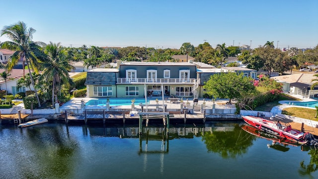 back of house with a water view, a balcony, and a patio