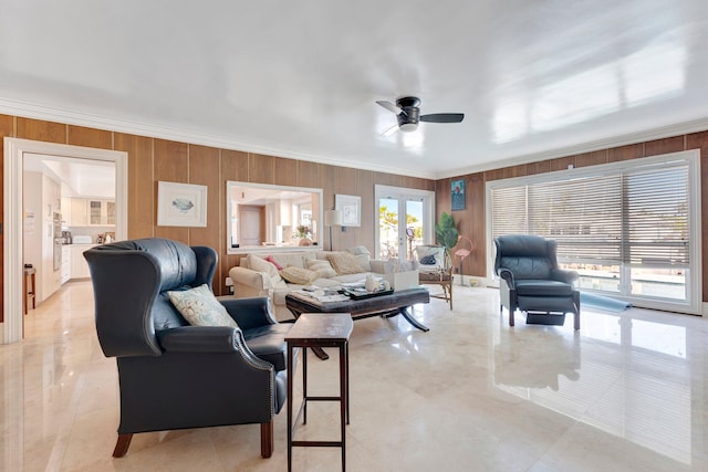 living room with ceiling fan, crown molding, french doors, and wooden walls