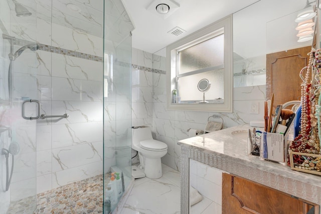 bathroom featuring vanity, a shower with door, toilet, and tile walls