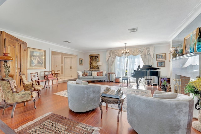 living room with crown molding, an inviting chandelier, and hardwood / wood-style flooring