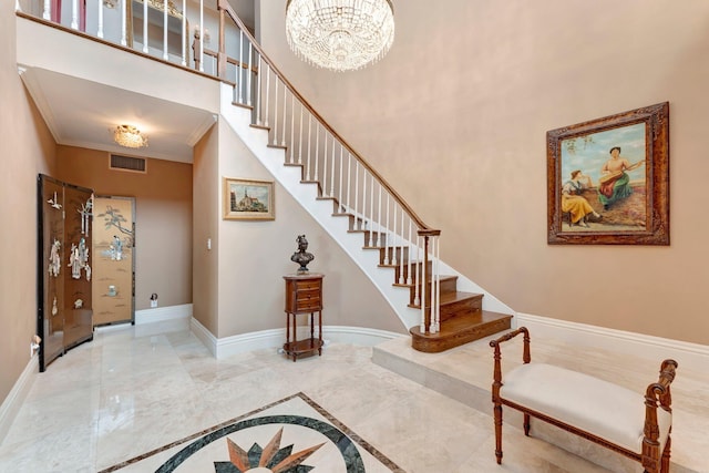 entrance foyer with a chandelier and ornamental molding